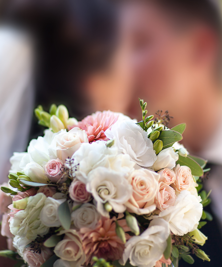 Wedding flowers with couple in the background 